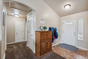 Entrance foyer with dark colored carpet