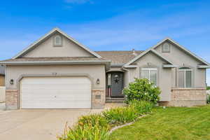 Ranch-style home featuring a garage and a front lawn