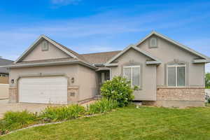 Single story home featuring a garage and a front lawn