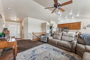 Living room with light carpet, lofted ceiling, and ceiling fan