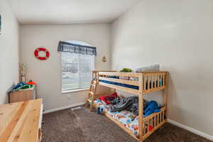 Bedroom with lofted ceiling and dark carpet