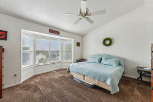 Primary bedroom Carpeted bedroom with vaulted ceiling and ceiling fan