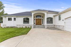 View of front of house featuring a garage, a porch, and a front lawn