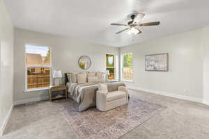 Primary Bedroom with ceiling fan and carpet flooring