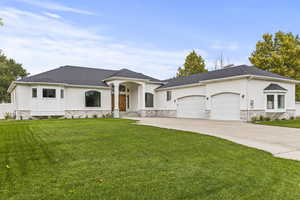 View of front of property featuring a front lawn and a garage