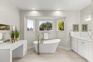 Primary Bathroom with a bathtub and vanity