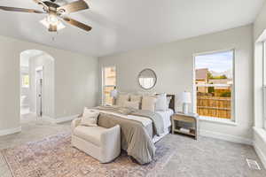 Primary Bedroom featuring ceiling fan, light colored carpet, and connected bathroom