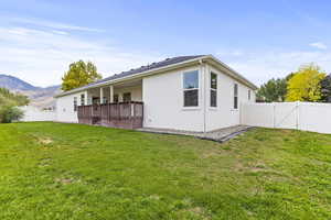 Rear view of house with a mountain view and a lawn