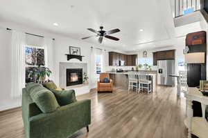 Living room with ceiling fan and light hardwood / wood-style floors