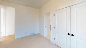 Unfurnished bedroom with a closet and light colored carpet