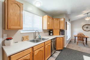 Kitchen featuring dishwasher, a textured ceiling, sink, light carpet, and ceiling fan