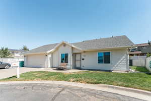 Ranch-style home featuring a front lawn and a garage