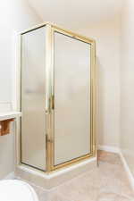 Bathroom with an enclosed shower and tile patterned floors