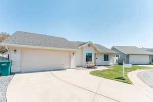 Single story home featuring a front yard and a garage