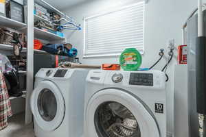 Laundry area with independent washer and dryer and tile patterned floors