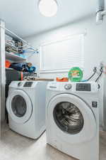 Laundry room with light tile patterned floors and washing machine and dryer