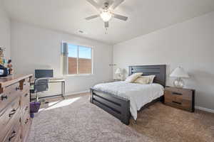 Bedroom with ceiling fan and light colored carpet