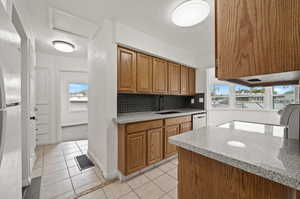 Kitchen featuring tasteful backsplash, sink, light tile patterned floors, and a wealth of natural light