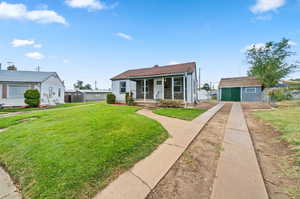 Bungalow-style house featuring a shed, a porch, and a front yard