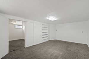 Basement with a textured ceiling and dark colored carpet