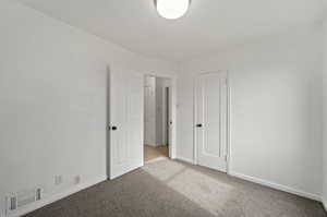 Unfurnished bedroom featuring light colored carpet