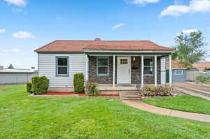 View of front of property featuring a porch and a front lawn