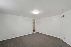 Unfurnished room with dark carpet