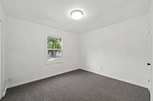 Unfurnished room with carpet floors and a textured ceiling