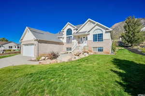 View of front of home featuring a front yard and a garage