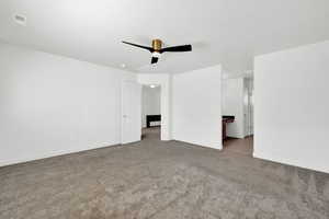 Unfurnished bedroom with ceiling fan and light carpet