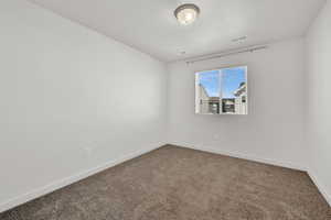 Spare room with a textured ceiling and carpet