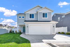 View of front of house featuring a front lawn and a garage