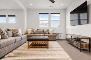 Carpeted living room featuring ceiling fan