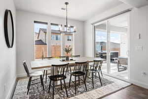 Dining space featuring a wealth of natural light, a chandelier, and dark hardwood / wood-style flooring