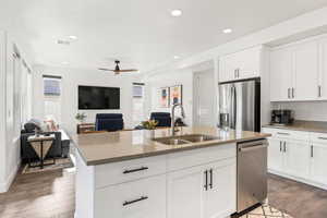 Kitchen with stainless steel appliances, white cabinets, and sink