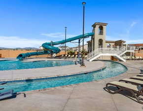 View of pool with a patio and a2 story  water slide