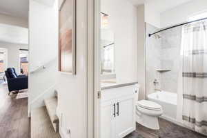 Full bathroom featuring shower / bath combo with shower curtain, a wealth of natural light, hardwood / wood-style floors, and vanity