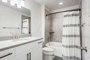 Full bathroom featuring shower / tub combo with curtain, vanity, and toilet