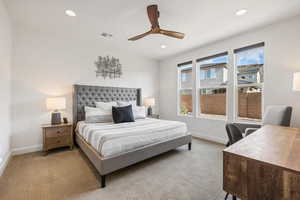 Carpeted bedroom featuring ceiling fan