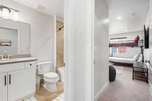 Full bathroom with tiled shower / bath combo, vanity, toilet, and tile patterned floors