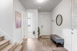 Foyer featuring light wood-type flooring and a textured ceiling