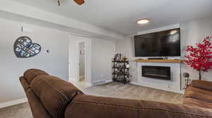 Living room with ceiling fan and light colored carpet