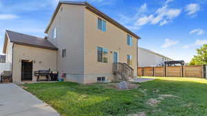 Back of property with a lawn and a patio area