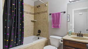 Full bathroom featuring shower / bath combo with shower curtain, vanity, and toilet