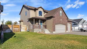 View of front facade with a front yard, a garage, and covered porch