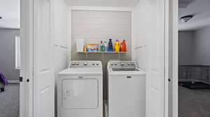 Clothes washing area featuring carpet and independent washer and dryer