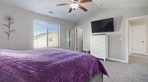 Carpeted bedroom featuring vaulted ceiling and ceiling fan