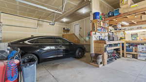 Garage featuring a garage door opener and a workshop area