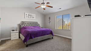 Bedroom featuring ceiling fan, vaulted ceiling, and carpet