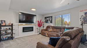 Carpeted living room with a textured ceiling and ceiling fan